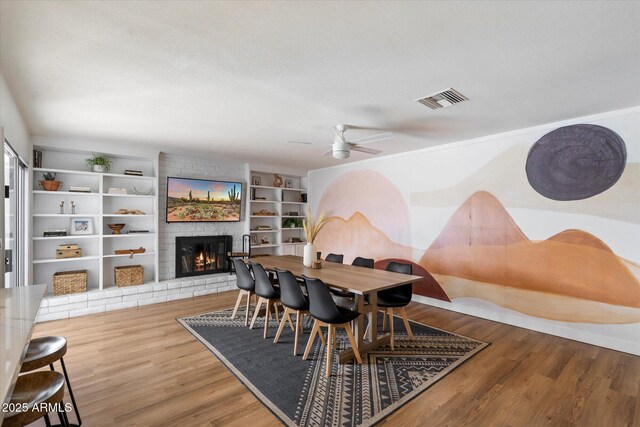 6271 E Evans Dr, Scottsdale, AZ 85254 - dining space featuring visible vents, a ceiling fan, wood finished floors, and a fireplace