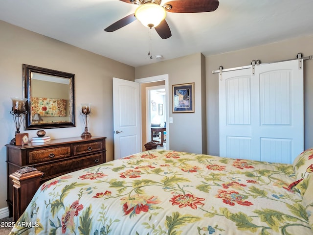 bedroom with a closet, a barn door, and ceiling fan