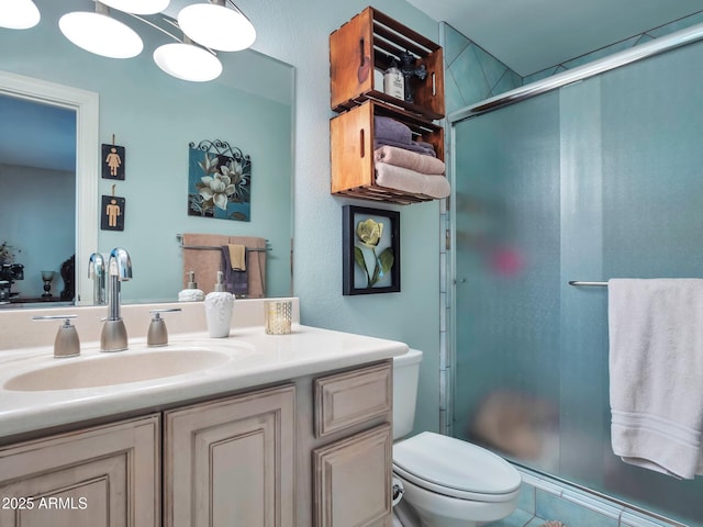 bathroom featuring walk in shower, vanity, and toilet