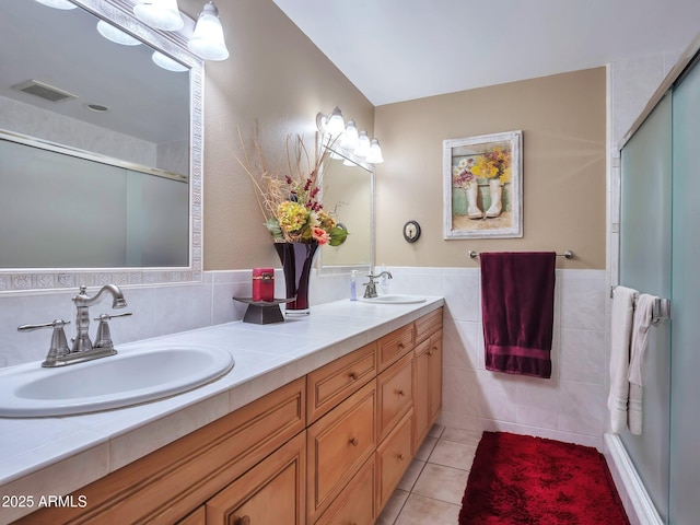 bathroom featuring an enclosed shower, vanity, tile walls, and tile patterned floors