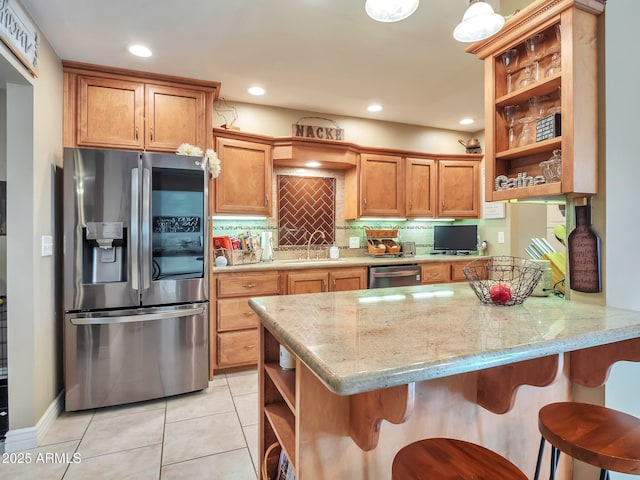 kitchen featuring stainless steel appliances, a kitchen bar, kitchen peninsula, and sink