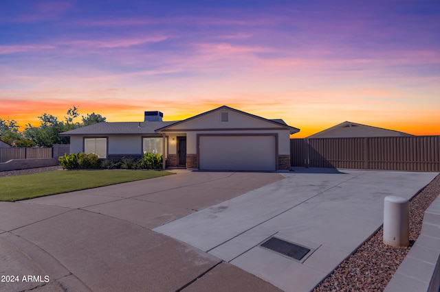 ranch-style house featuring stucco siding, a lawn, fence, a garage, and driveway