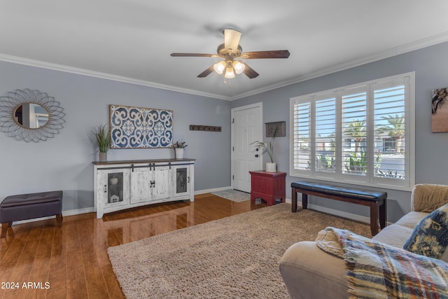 living area featuring crown molding, baseboards, and wood finished floors