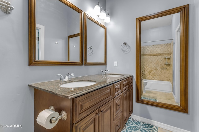 bathroom featuring double vanity, baseboards, and a sink