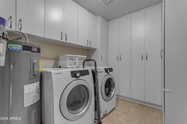 laundry area featuring light tile patterned flooring, cabinet space, washing machine and dryer, and electric water heater