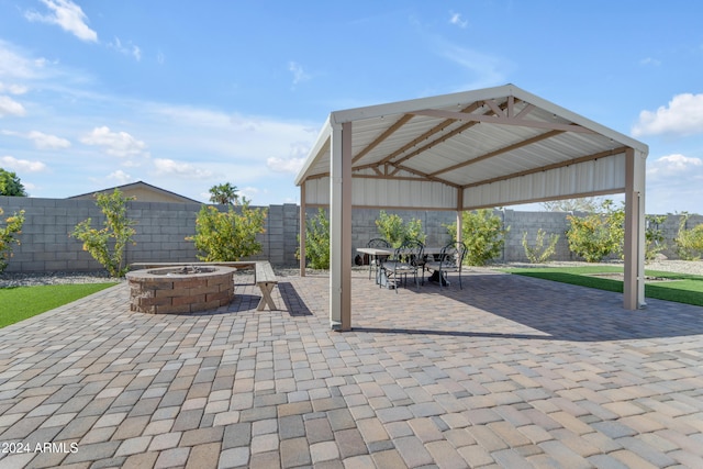 view of patio with an outdoor fire pit, a fenced backyard, and a gazebo