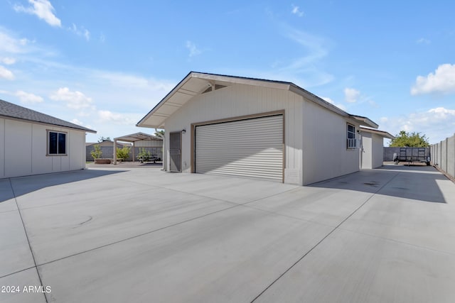 view of side of property featuring a garage, an outdoor structure, and fence