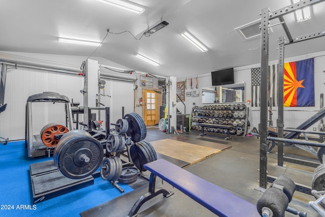 workout area with a garage and vaulted ceiling