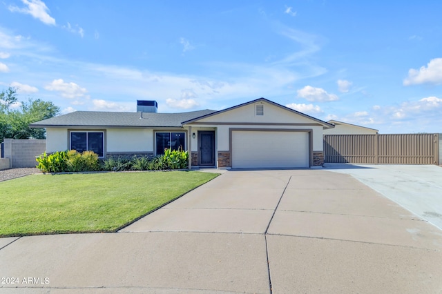 ranch-style house with a garage, fence, driveway, stucco siding, and a front lawn