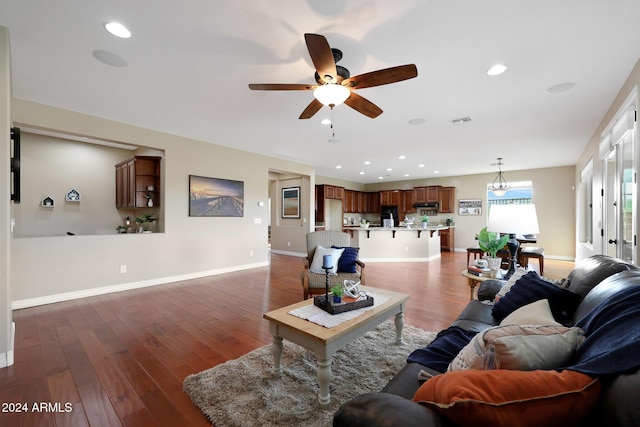 living area featuring baseboards, ceiling fan, visible vents, and wood finished floors