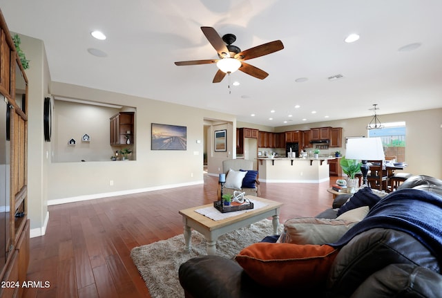 living room with ceiling fan and dark hardwood / wood-style flooring