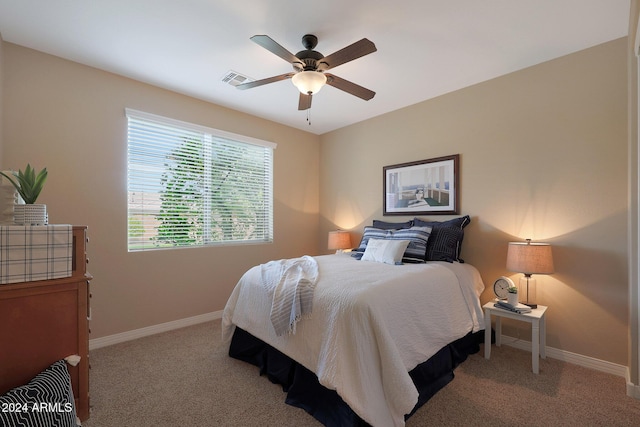 bedroom with light colored carpet, a ceiling fan, and baseboards