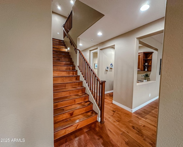 staircase featuring baseboards, recessed lighting, and wood finished floors