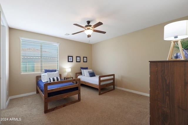 bedroom featuring baseboards, visible vents, ceiling fan, and light colored carpet