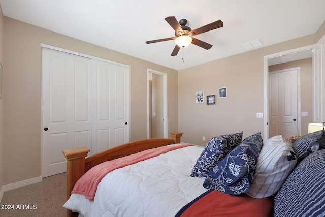 carpeted bedroom with a closet, a ceiling fan, baseboards, and visible vents
