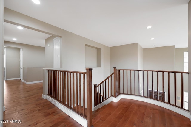 hall with wood-type flooring, recessed lighting, and an upstairs landing