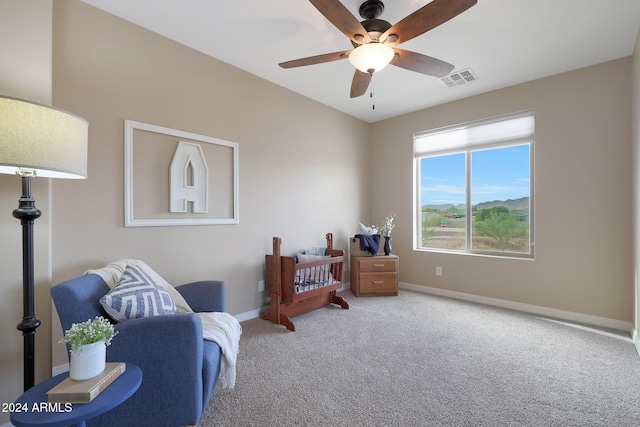 living area with visible vents, carpet flooring, baseboards, and a ceiling fan