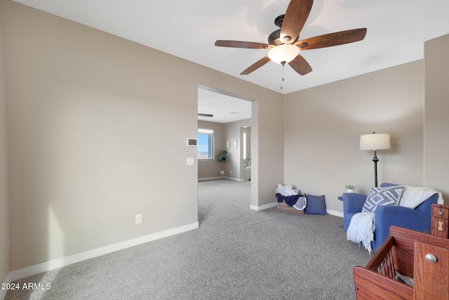 living area featuring carpet floors, baseboards, and ceiling fan