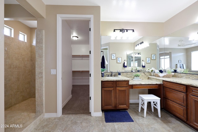 bathroom with vanity, ceiling fan, tile patterned floors, and tiled shower