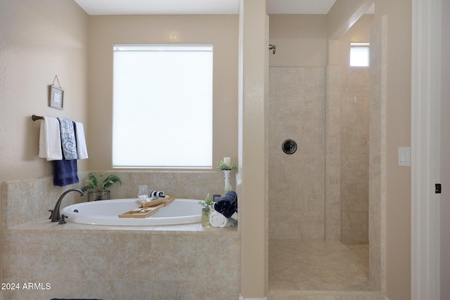 bathroom with a garden tub and tiled shower
