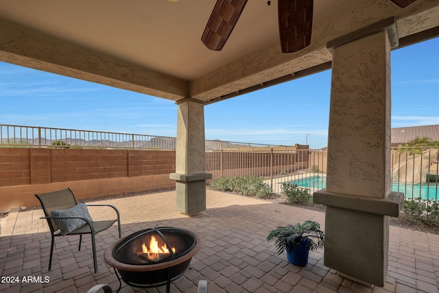 view of patio with a fenced in pool and a fire pit