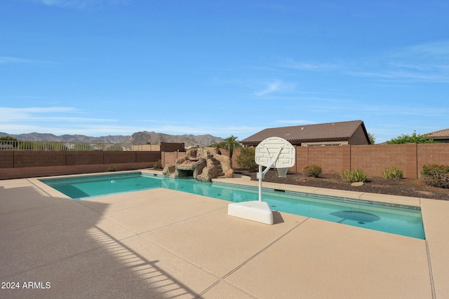 view of swimming pool with a fenced in pool, a fenced backyard, a mountain view, and a patio