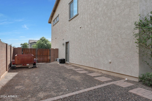 view of home's exterior with fence, a gate, and stucco siding