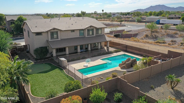 view of pool featuring a residential view, a fenced backyard, a fenced in pool, a mountain view, and a patio