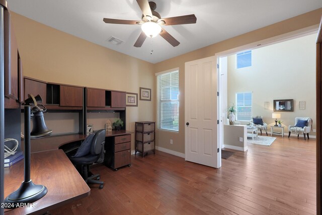 home office with visible vents, a ceiling fan, baseboards, and light wood-type flooring