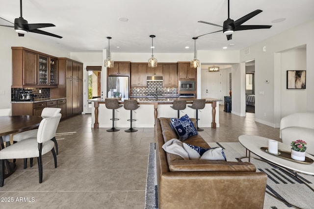 living area with baseboards, visible vents, a ceiling fan, and recessed lighting