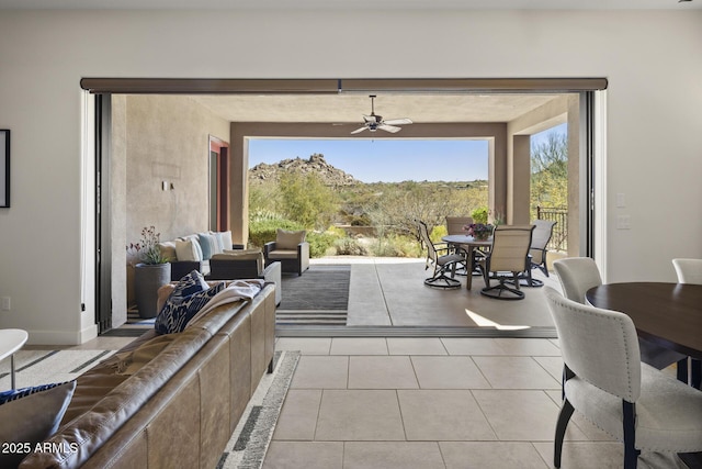 living area featuring light tile patterned floors and a ceiling fan