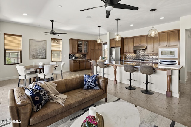 living area featuring recessed lighting, light tile patterned flooring, ceiling fan, and baseboards