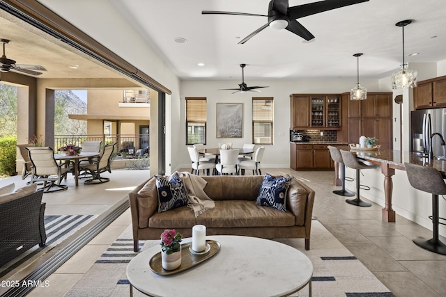 living area featuring baseboards, ceiling fan, light tile patterned flooring, and recessed lighting