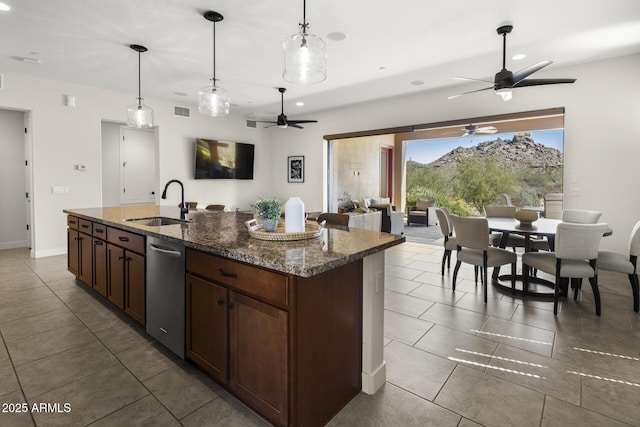 kitchen with stainless steel dishwasher, visible vents, a sink, and decorative light fixtures