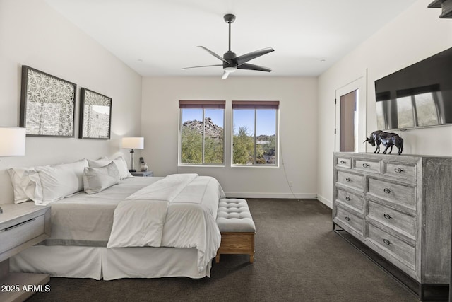 bedroom featuring baseboards, dark carpet, and a ceiling fan