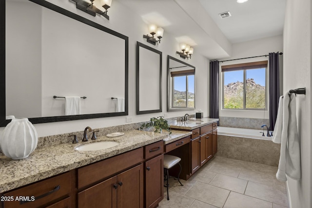 bathroom with a garden tub, double vanity, a sink, and visible vents