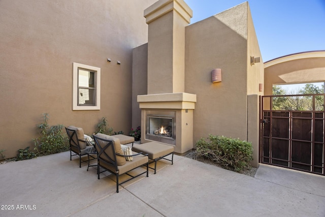 view of patio featuring a warm lit fireplace