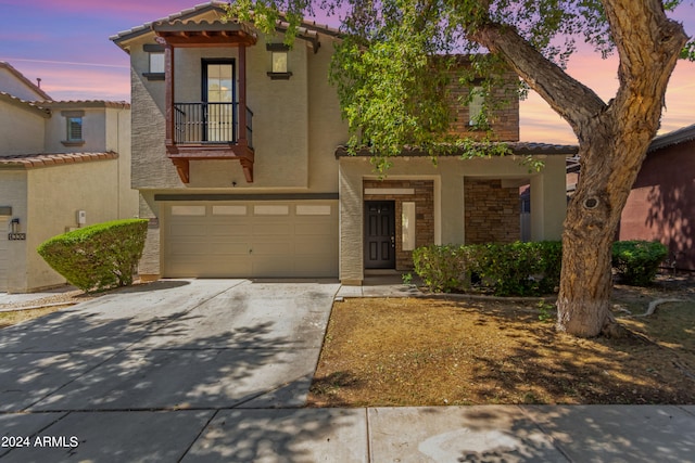 view of front of home with a garage and a balcony