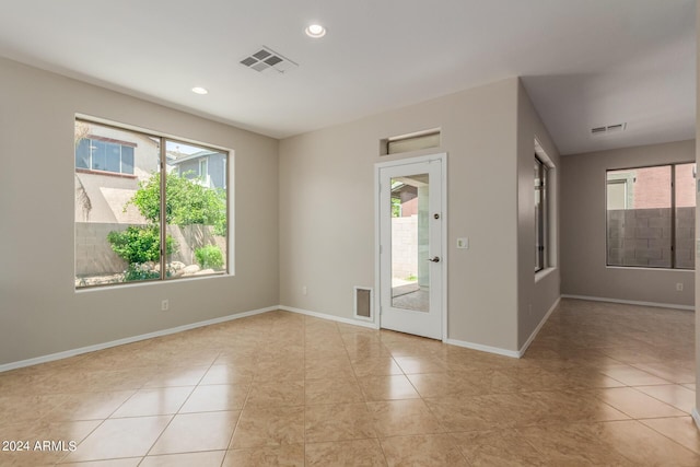 spare room with recessed lighting, visible vents, baseboards, and a healthy amount of sunlight