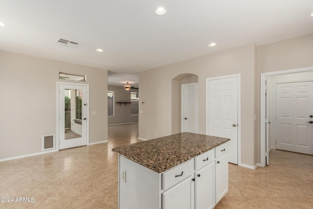 kitchen featuring arched walkways, visible vents, recessed lighting, and a center island