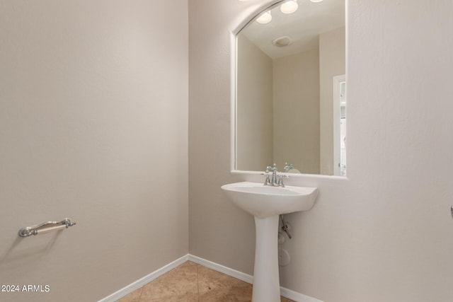 bathroom featuring tile patterned floors, baseboards, and a sink