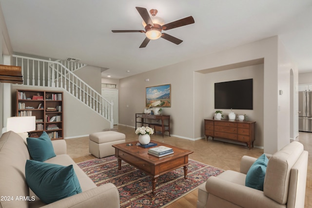 living area with visible vents, ceiling fan, baseboards, stairs, and arched walkways