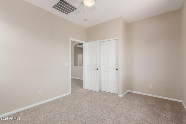 unfurnished bedroom with visible vents, a closet, carpet, baseboards, and ceiling fan