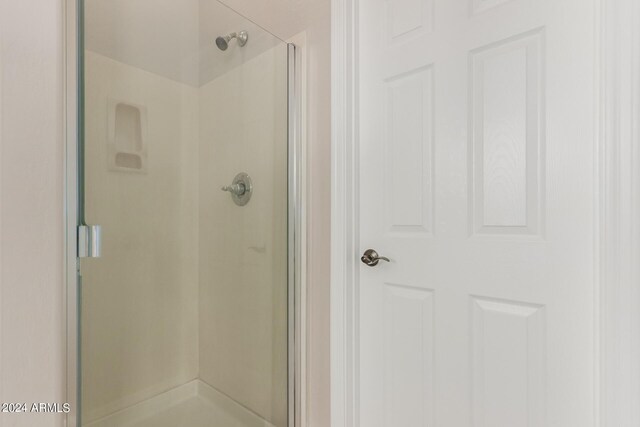 bathroom featuring a shower with door