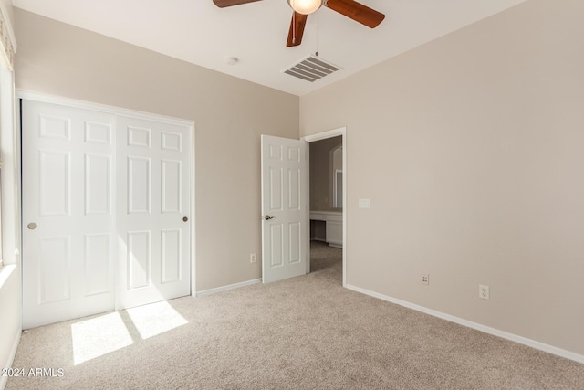 unfurnished bedroom featuring carpet flooring, ceiling fan, baseboards, and visible vents