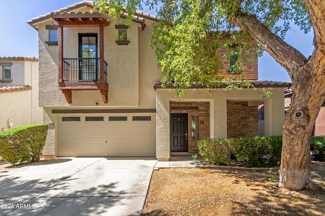 view of front facade featuring a tiled roof, stucco siding, a garage, stone siding, and driveway