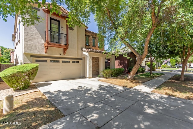 view of front facade with stucco siding, a garage, concrete driveway, and a tiled roof