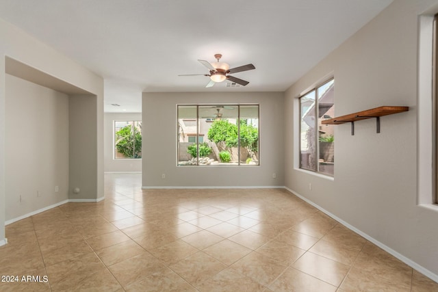 spare room with light tile patterned floors, baseboards, and a ceiling fan