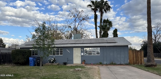 view of front facade with a front lawn and solar panels