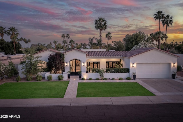 8045 E Del Caverna Dr, Scottsdale, AZ 85258 - mediterranean / spanish home featuring a garage, a front lawn, stucco siding, a tiled roof, and concrete driveway